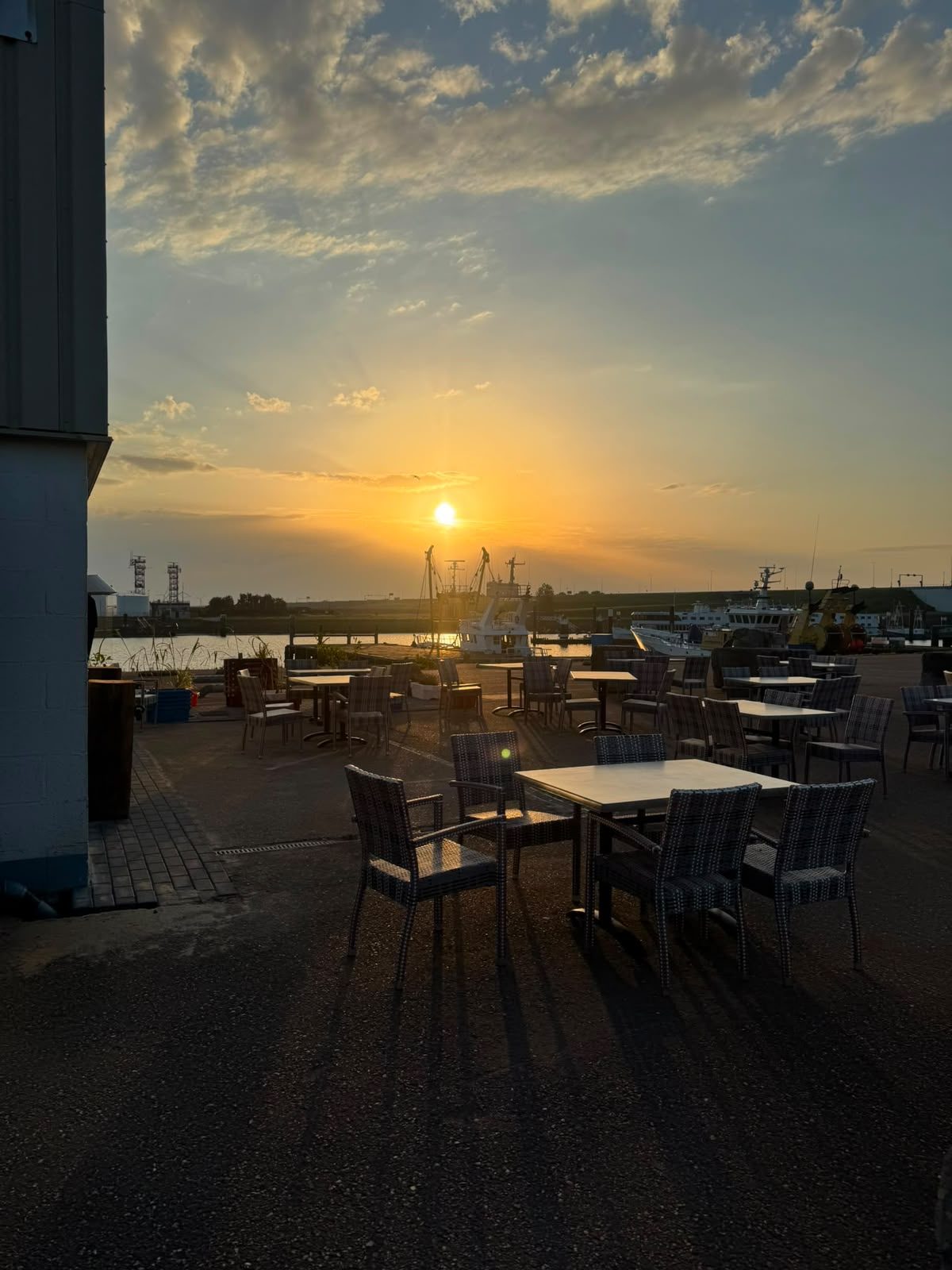 Het terras van De Ambachtswinkel bij zonsondergang — buitenhaven Stellendam