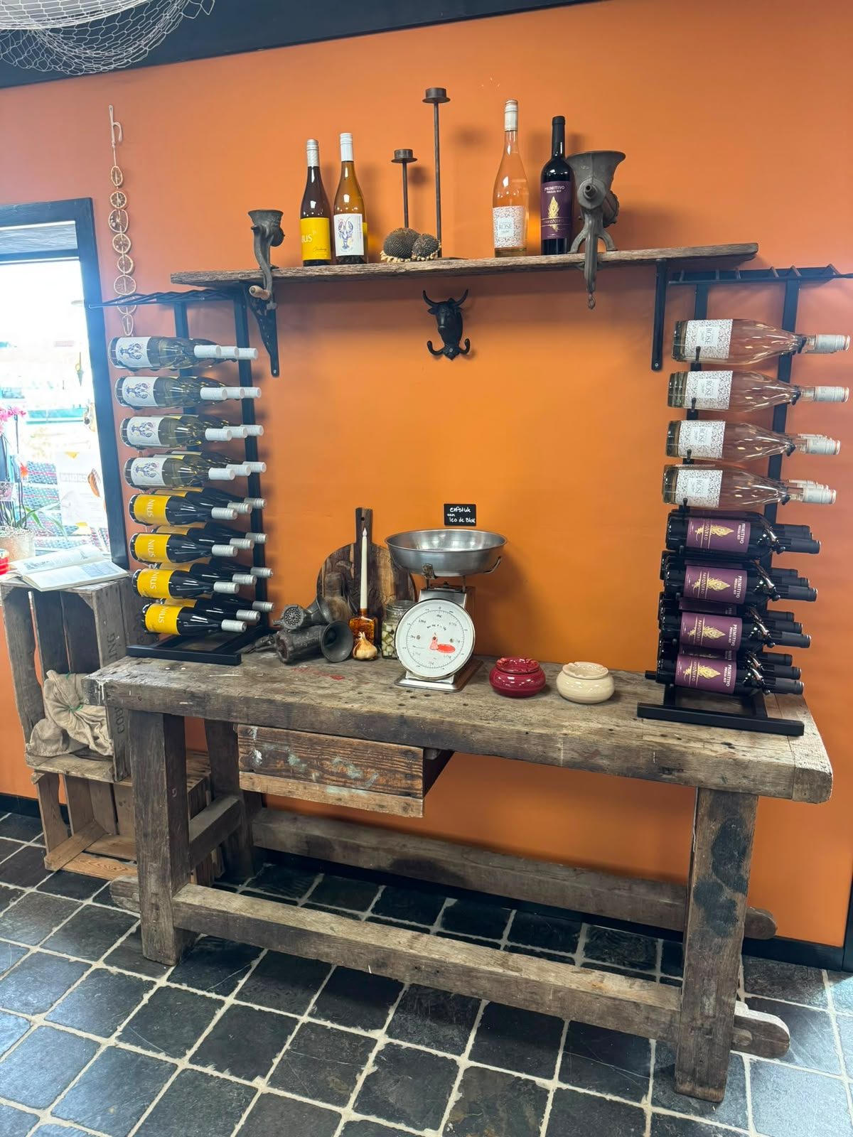 Wijnrek met lokale wijnen en ambachtelijke producten in De Ambachtswinkel
